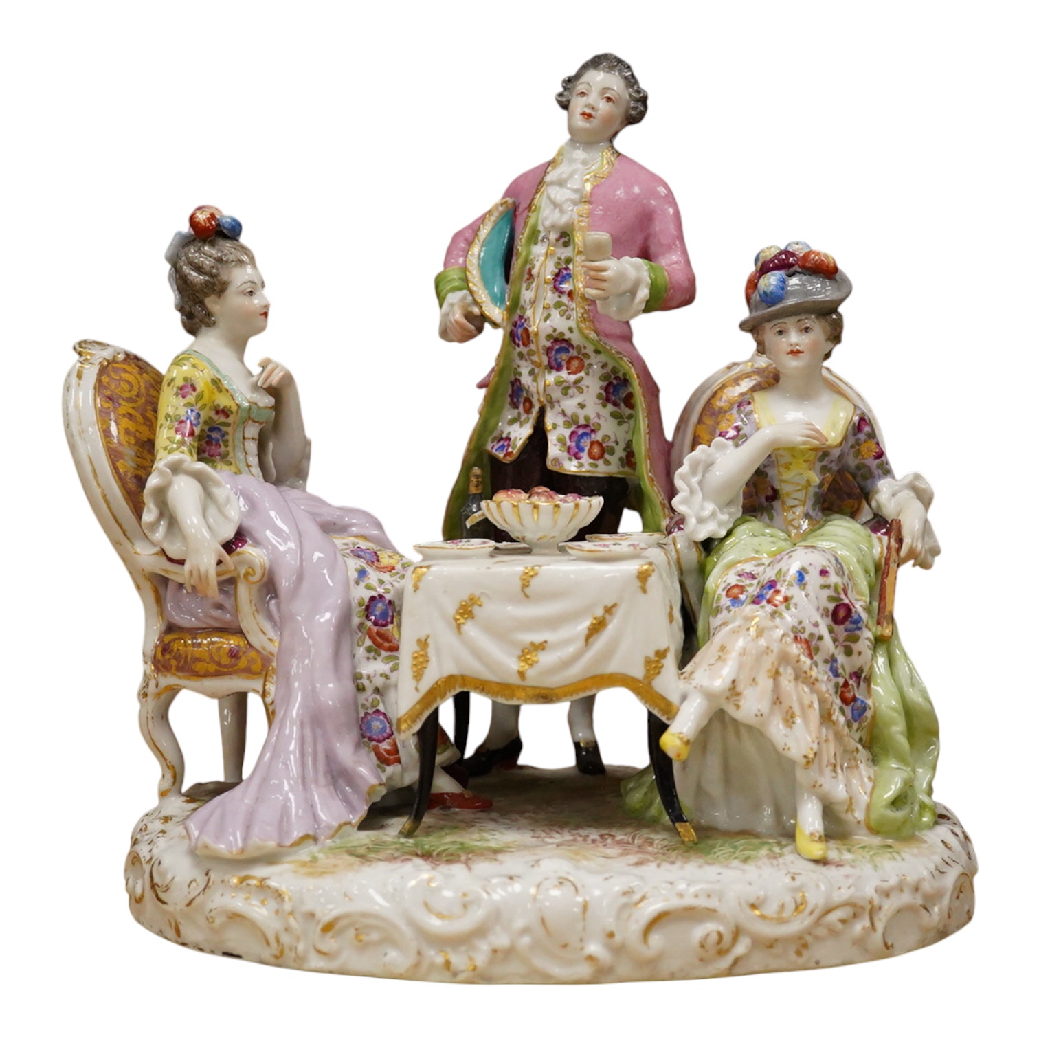 A 19th century Dresden porcelain group of three figures at a table, 24cm high